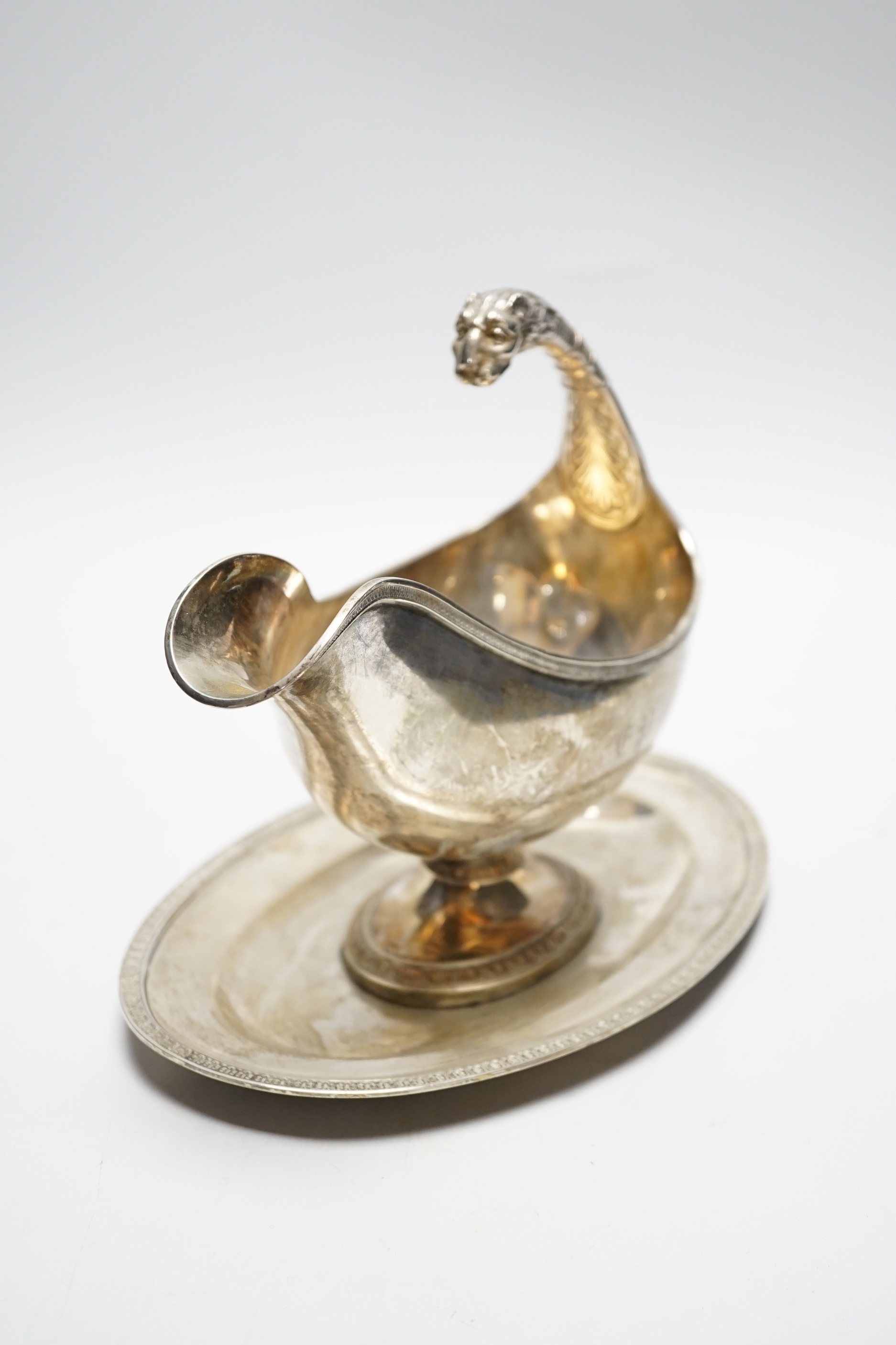 A continental white metal sauceboat on stand, with flying scroll leopard's head handle, length 23.8cm, 24.7oz.